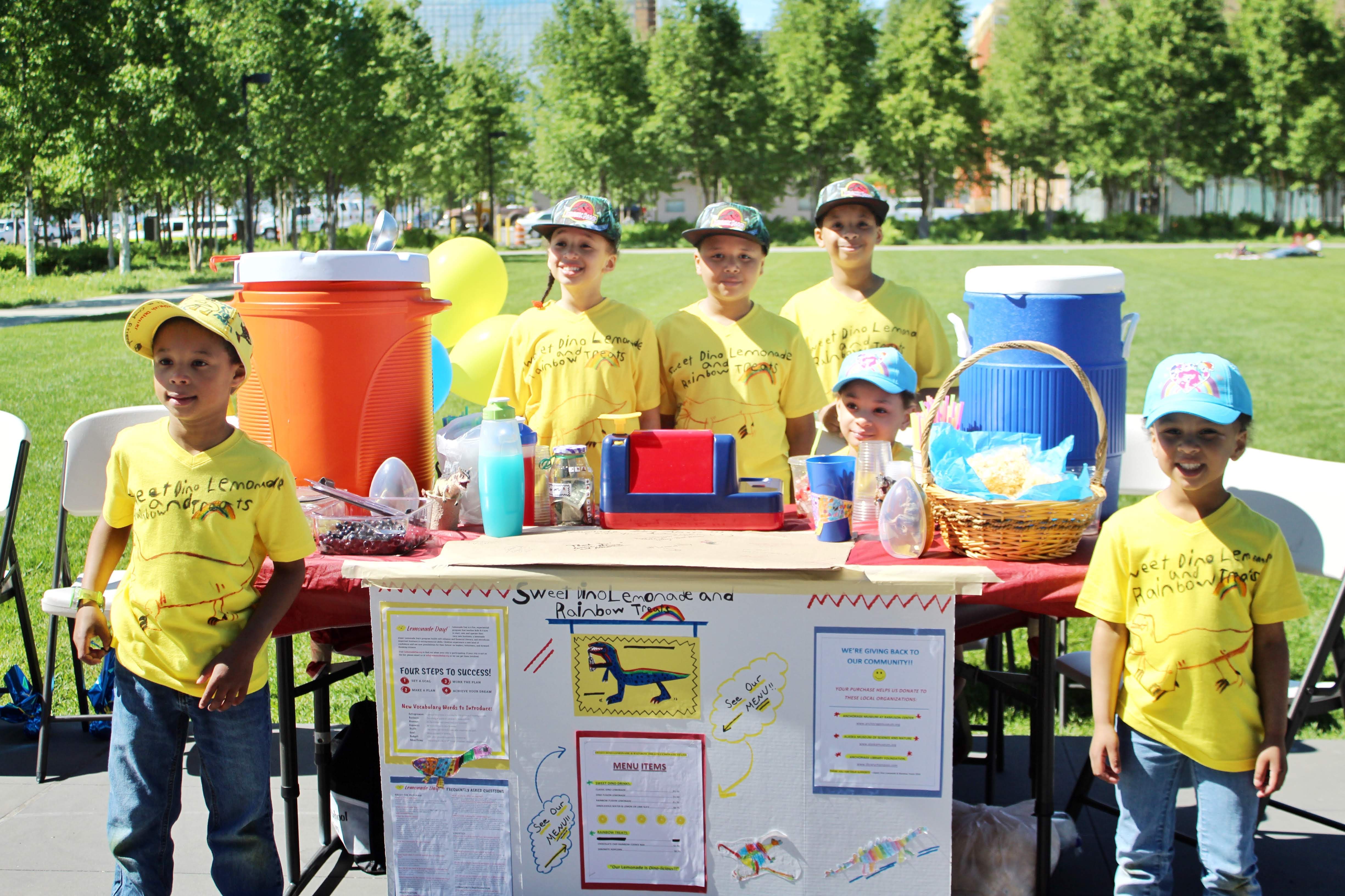 Group of boys with a dinosaur themed lemonade stand
