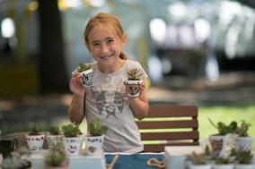 Kid with blonde hair selling her plants